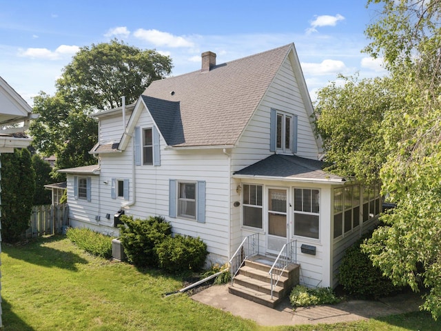 715 N 4th St, Dekalb, IL 60115 - view of front of house with a shingled roof, a sunroom, a chimney, and entry steps