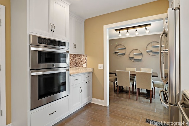 627 Bayview Pt, Schaumburg, IL 60194 - kitchen featuring appliances with stainless steel finishes, backsplash, white cabinetry, dark wood-style flooring, and light stone countertops