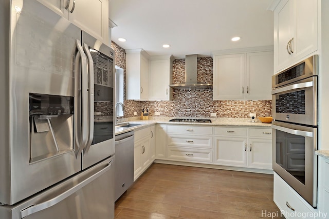 627 Bayview Pt, Schaumburg, IL 60194 - kitchen with stainless steel appliances, wall chimney range hood, white cabinets, tasteful backsplash, and recessed lighting