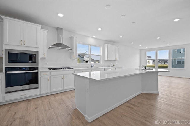 2308 Lawlor Ln, Naperville, IL 60564 - kitchen featuring appliances with stainless steel finishes, wall chimney exhaust hood, light wood finished floors, white cabinetry, and recessed lighting