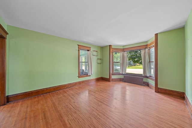220 N Cedar St, Waterman, IL 60556 - empty room with radiator heating unit and wood finished floors
