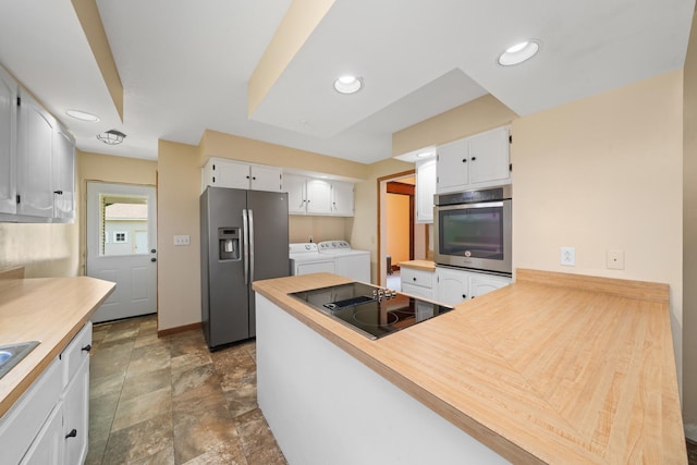 220 N Cedar St, Waterman, IL 60556 - kitchen with appliances with stainless steel finishes, washing machine and clothes dryer, white cabinetry, a peninsula, and recessed lighting