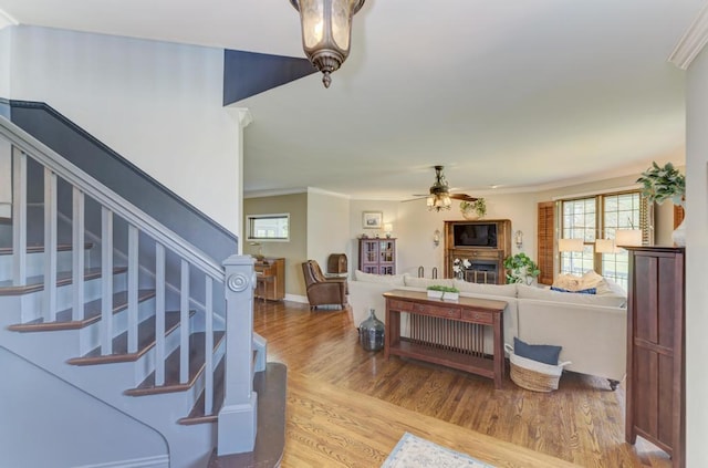 26 Carriage House Ln, Orland Park, IL 60467 - living room featuring light wood-type flooring, ceiling fan, ornamental molding, healthy amount of natural light, and stairs