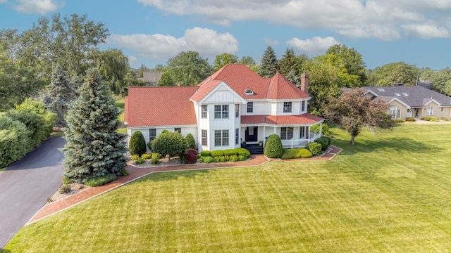 26 Carriage House Ln, Orland Park, IL 60467 - view of front facade featuring a porch, a chimney, a front lawn, and board and batten siding