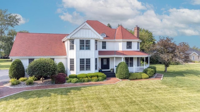 26 Carriage House Ln, Orland Park, IL 60467 - view of front of property with a porch, a chimney, a front yard, and board and batten siding