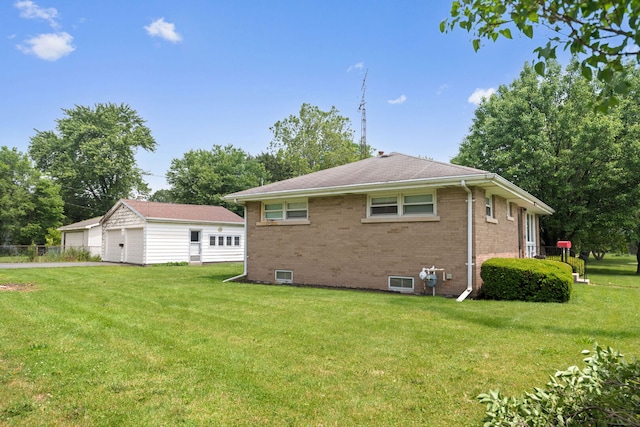 345 W Jeffery St, Kankakee, IL 60901 - back of property with a detached garage, brick siding, and a yard