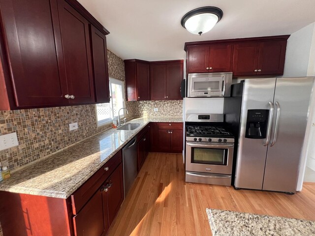 11133 Boeger Ct, Westchester, IL 60154 - kitchen featuring appliances with stainless steel finishes, light wood finished floors, reddish brown cabinets, and light stone counters