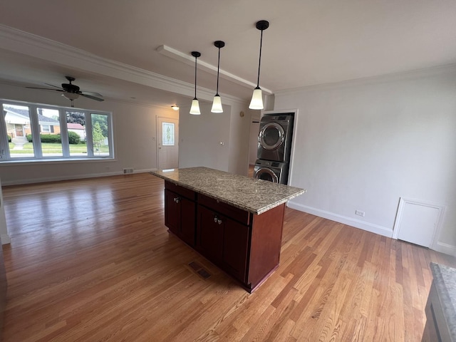 11133 Boeger Ct, Westchester, IL 60154 - kitchen featuring stacked washer / dryer, crown molding, a ceiling fan, light wood finished floors, and open floor plan
