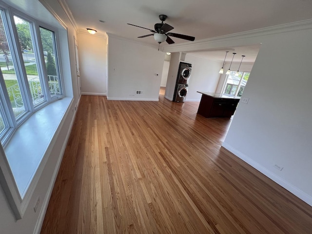 11133 Boeger Ct, Westchester, IL 60154 - unfurnished living room featuring estacked washer and dryer, ornamental molding, wood finished floors, and ceiling fan