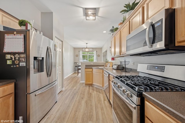 142 W Park Ave Unit C, Sugar Grove, IL 60554 - kitchen featuring appliances with stainless steel finishes, light brown cabinetry, light wood-style flooring, a peninsula, and dark countertops