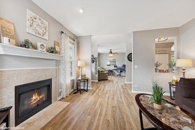 142 W Park Ave Unit C, Sugar Grove, IL 60554 - living room featuring a tiled fireplace, wood finished floors, and ceiling fan