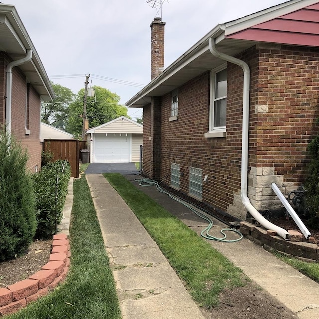 1525 Morgan Ave, La Grange Park, IL 60526 - view of side of home featuring a detached garage, driveway, a chimney, brick siding, and an outdoor structure