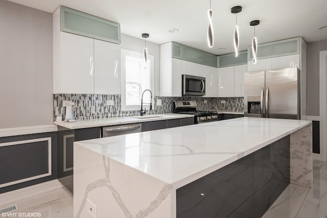 11616 S Lowe Ave, Chicago, IL 60628 - kitchen featuring appliances with stainless steel finishes, tasteful backsplash, light stone counters, and pendant lighting