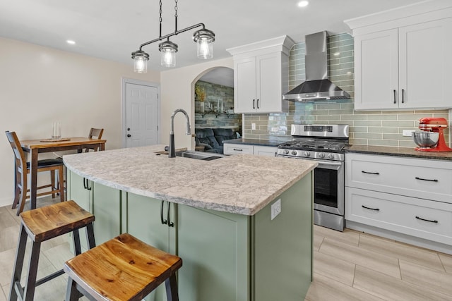 277 Mcmillan St, Grayslake, IL 60030 - kitchen with wall chimney exhaust hood, stainless steel gas range, green cabinetry, decorative backsplash, and recessed lighting