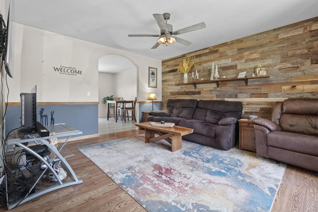 277 Mcmillan St, Grayslake, IL 60030 - living room featuring arched walkways, wood walls, ceiling fan, and wood finished floors