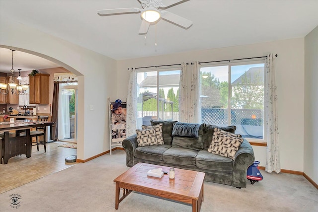 1612 Whisper Glen Dr, Plainfield, IL 60586 - living room featuring light colored carpet, arched walkways, a chandelier, and a ceiling fan