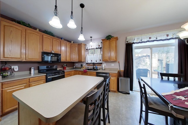 1612 Whisper Glen Dr, Plainfield, IL 60586 - kitchen featuring black appliances, light countertops, a center island, pendant lighting, and a kitchen bar