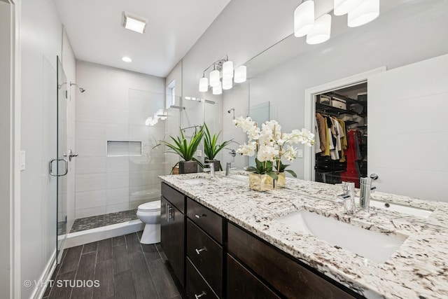 2503 N Maplewood Ave, Chicago, IL 60647 - bathroom with double vanity, a stall shower, a walk in closet, recessed lighting, and wood tiled floors