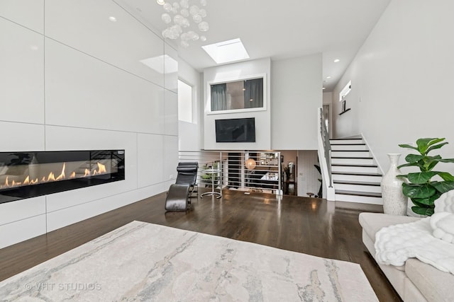 2503 N Maplewood Ave, Chicago, IL 60647 - living room with a glass covered fireplace, wood finished floors, a skylight, stairway, and recessed lighting
