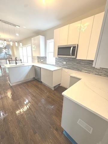 9432 S Vernon Ave, Chicago, IL 60619 - kitchen with stainless steel appliances, dark wood finished floors, a peninsula, backsplash, and light countertops