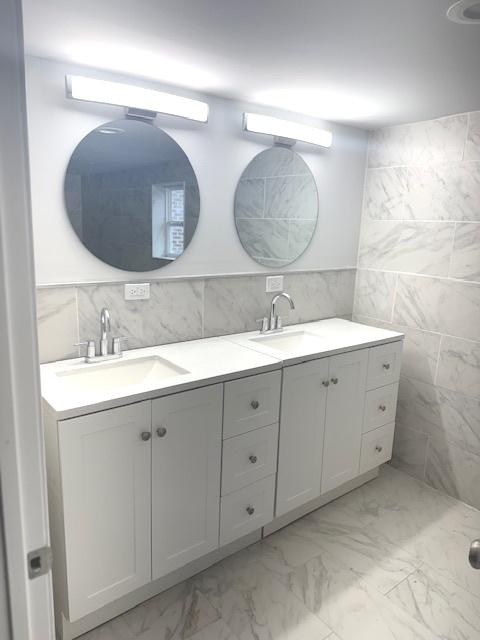 9432 S Vernon Ave, Chicago, IL 60619 - bathroom featuring marble look tile flooring, tile walls, and double vanity