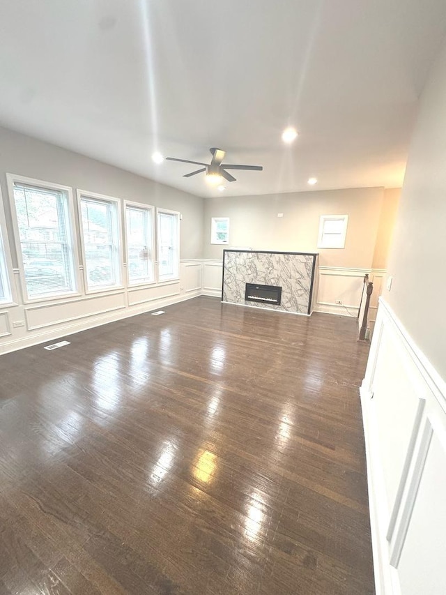 9432 S Vernon Ave, Chicago, IL 60619 - unfurnished living room with ceiling fan, a wainscoted wall, a stone fireplace, dark wood-type flooring, and recessed lighting