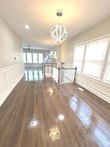 9432 S Vernon Ave, Chicago, IL 60619 - spare room featuring a decorative wall, a chandelier, wainscoting, and wood finished floors
