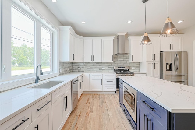 7948 W 74th Ave, Bridgeview, IL 60455 - kitchen featuring appliances with stainless steel finishes, wall chimney range hood, light wood-style floors, white cabinetry, and backsplash