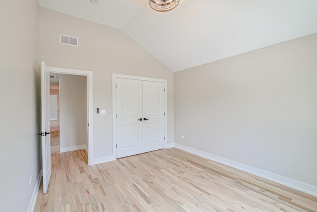 7948 W 74th Ave, Bridgeview, IL 60455 - unfurnished bedroom featuring light wood-style floors, vaulted ceiling, and a closet
