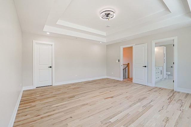 7948 W 74th Ave, Bridgeview, IL 60455 - unfurnished bedroom featuring a raised ceiling, light wood-style floors, ensuite bath, and recessed lighting