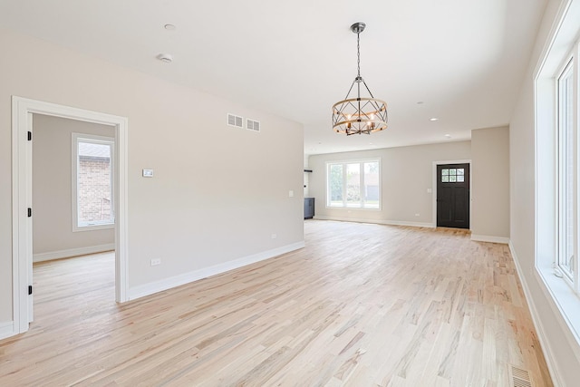 7948 W 74th Ave, Bridgeview, IL 60455 - unfurnished living room with a chandelier and light wood-type flooring