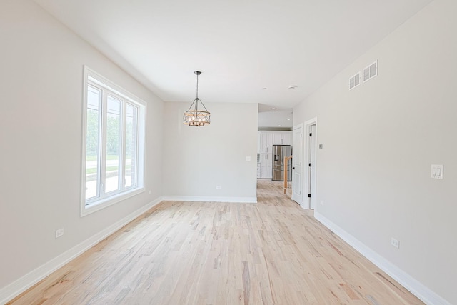 7948 W 74th Ave, Bridgeview, IL 60455 - unfurnished room featuring a chandelier and light wood-style floors