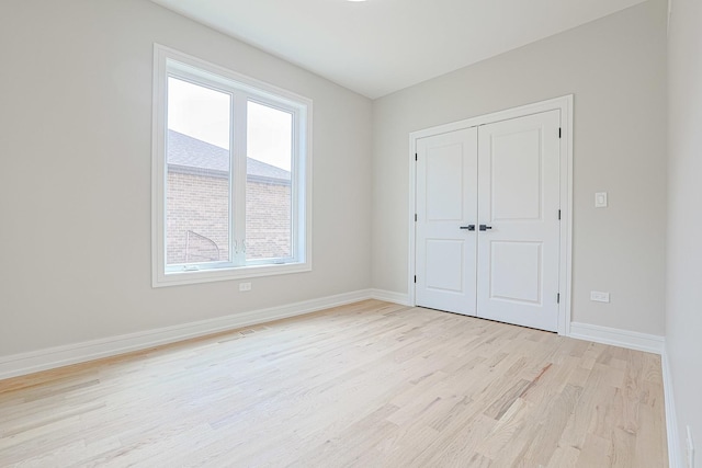 7948 W 74th Ave, Bridgeview, IL 60455 - unfurnished bedroom featuring light wood-style flooring and a closet