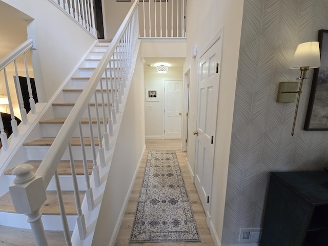 1530 Laurel Oaks Dr, Streamwood, IL 60107 - stairs featuring wallpapered walls, a towering ceiling, and wood finished floors