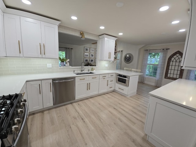 1530 Laurel Oaks Dr, Streamwood, IL 60107 - kitchen with appliances with stainless steel finishes, a peninsula, light countertops, light wood-style floors, and recessed lighting