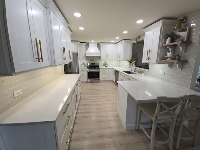 1530 Laurel Oaks Dr, Streamwood, IL 60107 - kitchen with appliances with stainless steel finishes, custom exhaust hood, decorative backsplash, light wood-style floors, and a peninsula