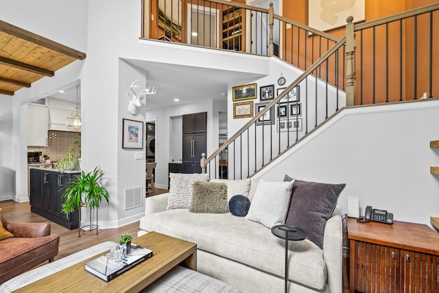 638 Legend Ln, Mchenry, IL 60050 - living area featuring estacked washer and dryer, stairway, wood finished floors, a towering ceiling, and a wood ceiling with exposed beams