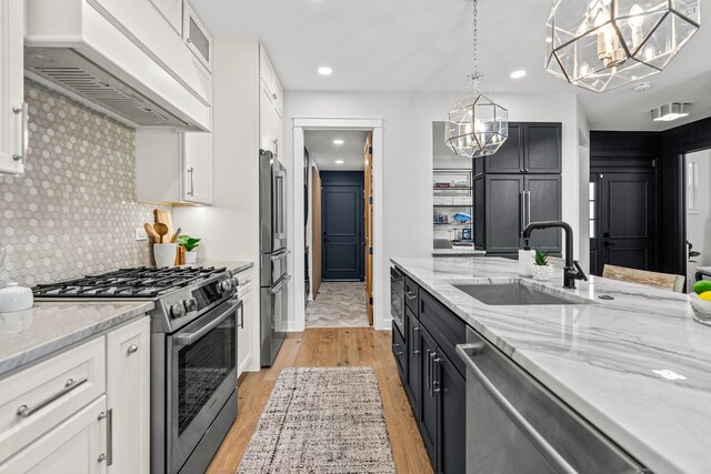 638 Legend Ln, Mchenry, IL 60050 - kitchen featuring stainless steel appliances, premium range hood, a chandelier, decorative backsplash, and white cabinetry