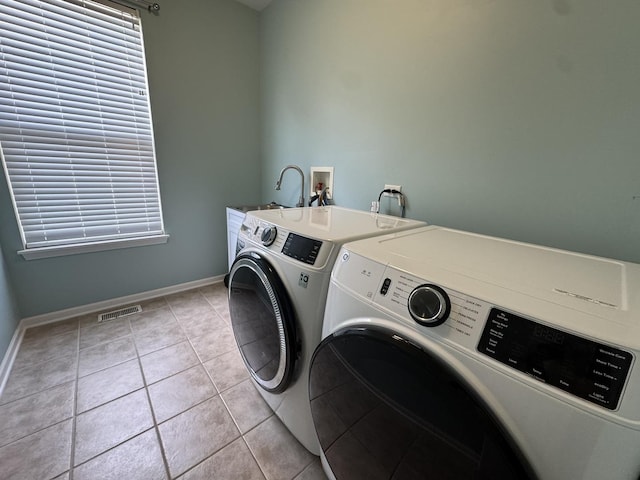 3122 Kyra Ln, Elgin, IL 60124 - laundry area with washing machine and clothes dryer, light tile patterned floors, and cabinet space