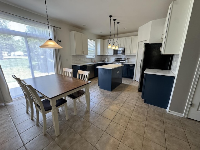 3122 Kyra Ln, Elgin, IL 60124 - kitchen with stainless steel appliances, a kitchen island, backsplash, light tile patterned floors, and light countertops