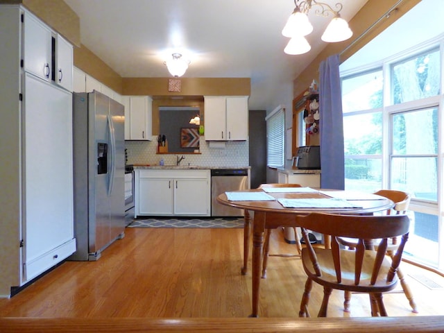 1420 E Lake Louise Dr, Palatine, IL 60074 - kitchen featuring appliances with stainless steel finishes, wood finished floors, white cabinetry, a chandelier, and tasteful backsplash