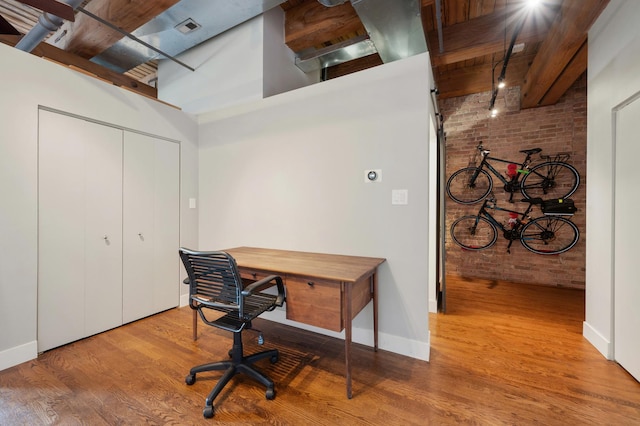400 S Green St Unit 406, Chicago, IL 60607 - home office featuring brick wall, wood finished floors, a high ceiling, and beam ceiling