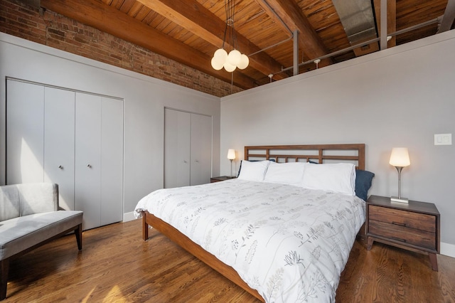 400 S Green St Unit 406, Chicago, IL 60607 - bedroom featuring two closets, a wood ceiling with exposed beams, wood finished floors, and brick wall
