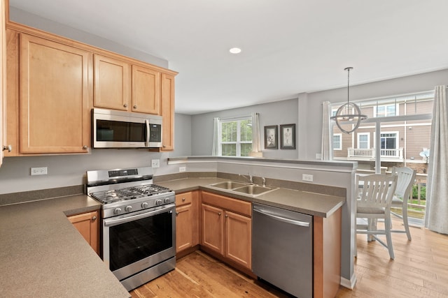 3072 Bridgeham St, Elgin, IL 60124 - kitchen featuring stainless steel appliances, a peninsula, light wood-style floors, a chandelier, and light brown cabinets