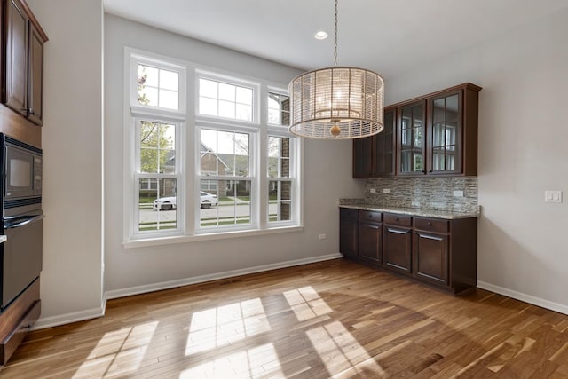 2929 Portage St, Naperville, IL 60564 - kitchen featuring black microwave, oven, dark brown cabinetry, backsplash, and light wood-style floors
