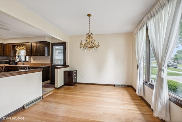 9133 Moody Ave, Oak Lawn, IL 60453 - kitchen with dark brown cabinets, a chandelier, light wood finished floors, and plenty of natural light