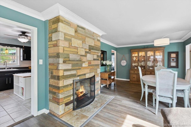 9122 S Avers Ave, Evergreen Park, IL 60805 - dining room featuring a stone fireplace, wood finished floors, a ceiling fan, and ornamental molding