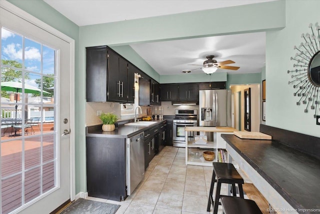 9122 S Avers Ave, Evergreen Park, IL 60805 - kitchen featuring stainless steel appliances, dark cabinetry, tasteful backsplash, and light tile patterned floors