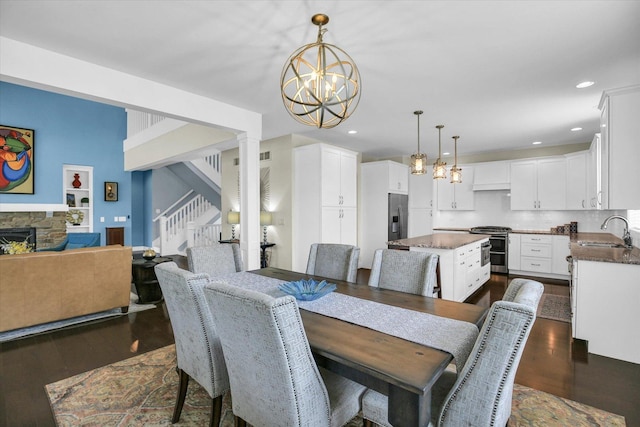 2955 E Stone Creek Blvd, Urbana, IL 61802 - dining space with a chandelier, dark wood finished floors, stairway, a fireplace, and recessed lighting