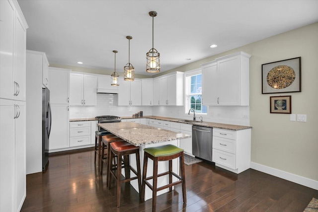 2955 E Stone Creek Blvd, Urbana, IL 61802 - kitchen with appliances with stainless steel finishes, dark wood-style flooring, white cabinetry, a kitchen island, and light stone countertops